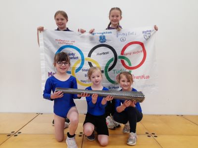 Gymnastics team with Olympic torch and flag