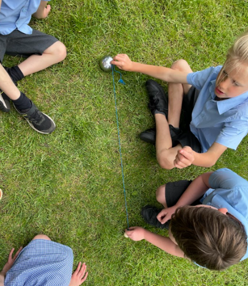 Children measuring distance of boule